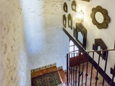 Treppendetail mit Terrakottastufen und einer Wand, die mit rustikalen Spiegeln in Teulada geschmückt ist.