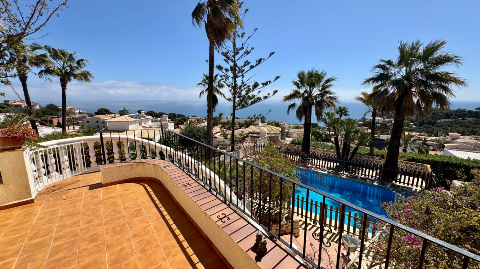 Erhöhte Terrasse mit Terrakotta-Fliesen und Schmiedeeisengeländer mit Blick auf den privaten Pool und das Mittelmeer.