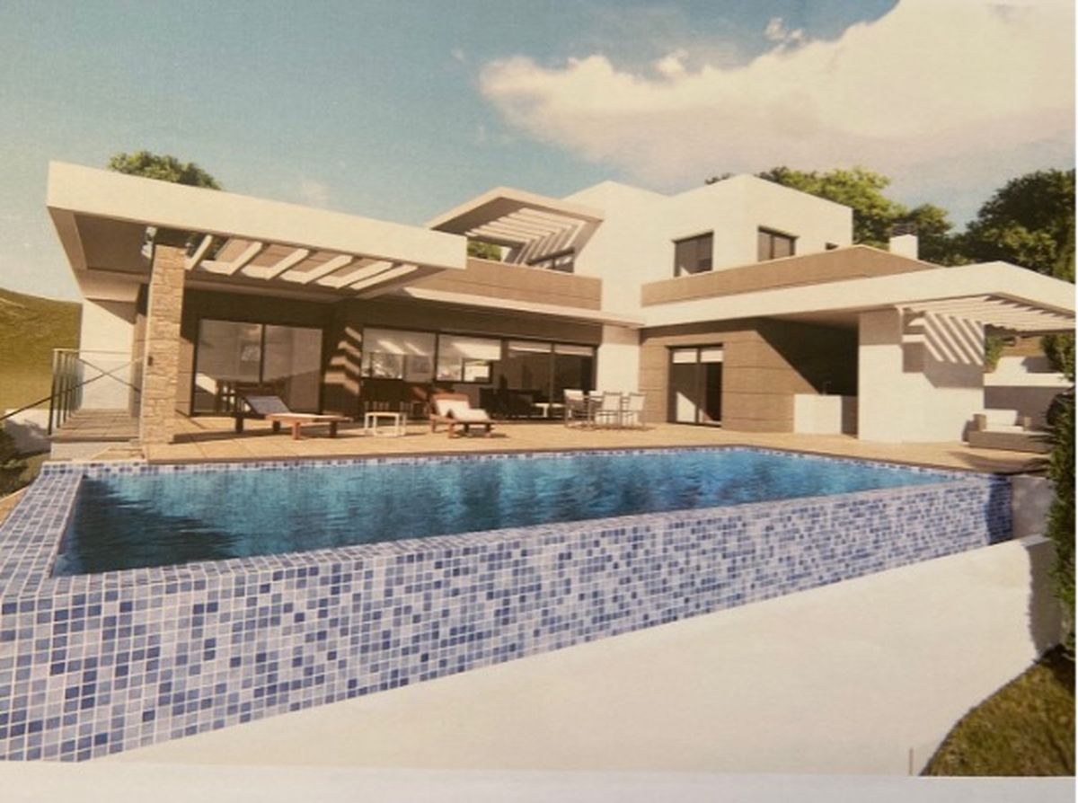 Moderne Villa mit Infinity-Pool aus blauen Mosaikfliesen, großzügiger Sonnenterrasse und zeitgenössischer Architektur mit Natursteinelementen.