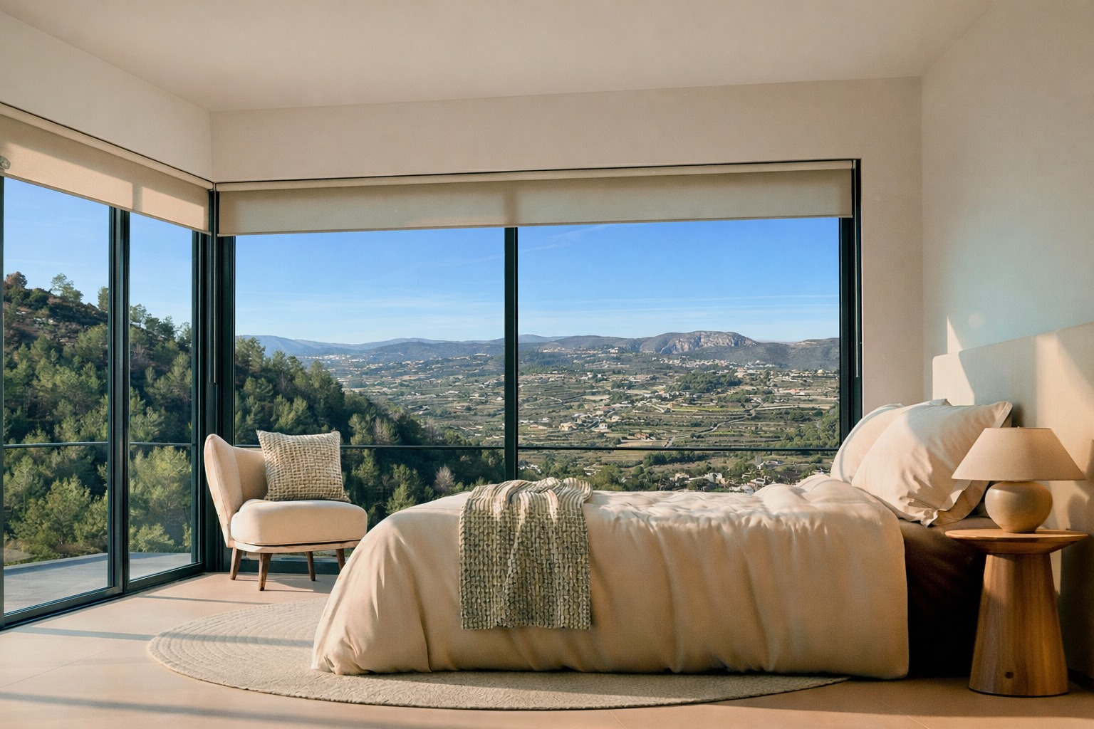 Schlafzimmer mit bodentiefen Eckfenstern und Panoramablick auf das Tal und die Berge. Neutrale Farbtöne, Holznachttisch und viel natürliches Licht.