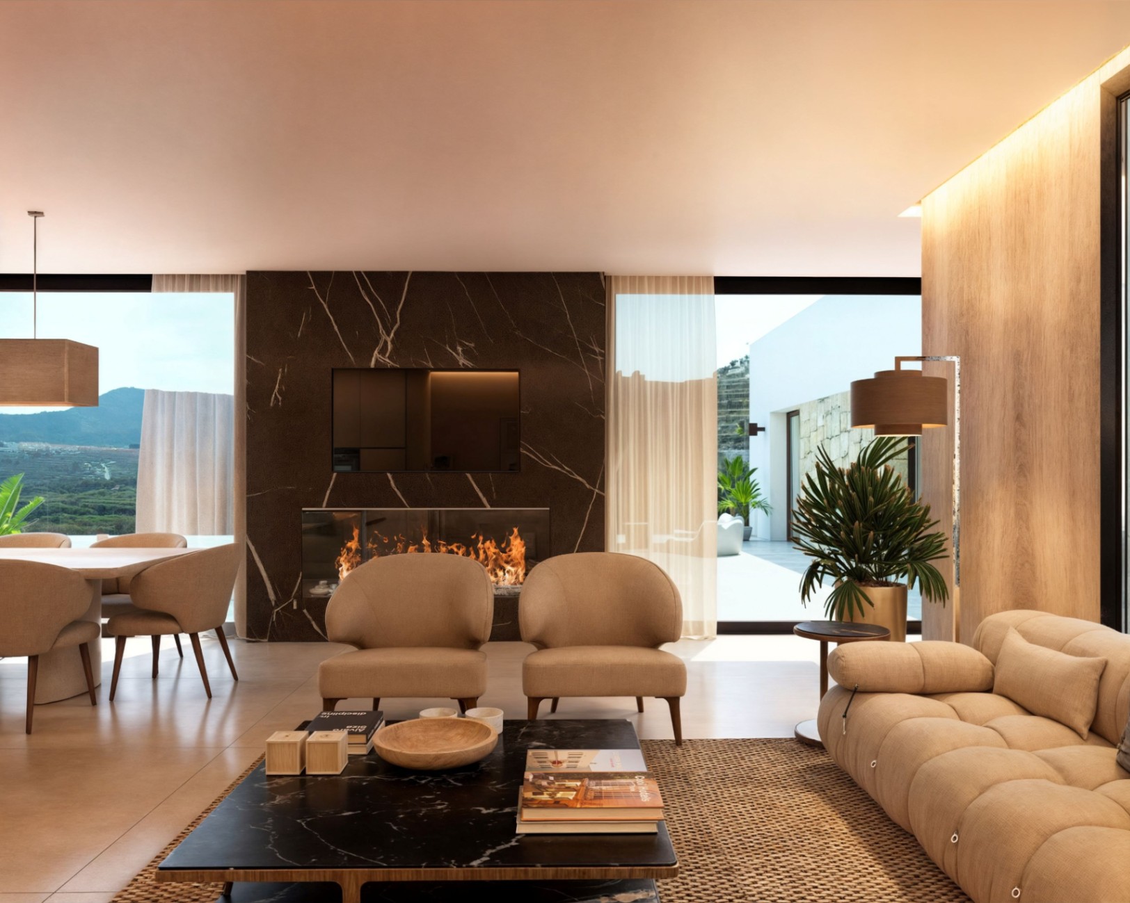 Modernes Wohnzimmer mit einer Kaminwand aus dunklem Marmor, integriertem Fernseher und bodentiefen Fenstern mit Blick auf die umliegende Berglandschaft.