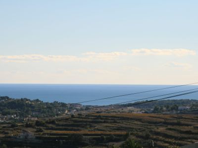 Blick auf das Grundstück mit dem Mittelmeer im Hintergrund, das seine Lage und sein landschaftliches Potenzial zeigt.