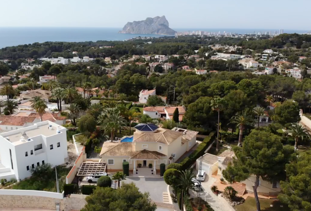 Luftbild der Villa mit traditioneller Architektur, blauem Kuppeldach und Blick über die mediterrane Landschaft auf das Meer und den Peñón de Ifach.