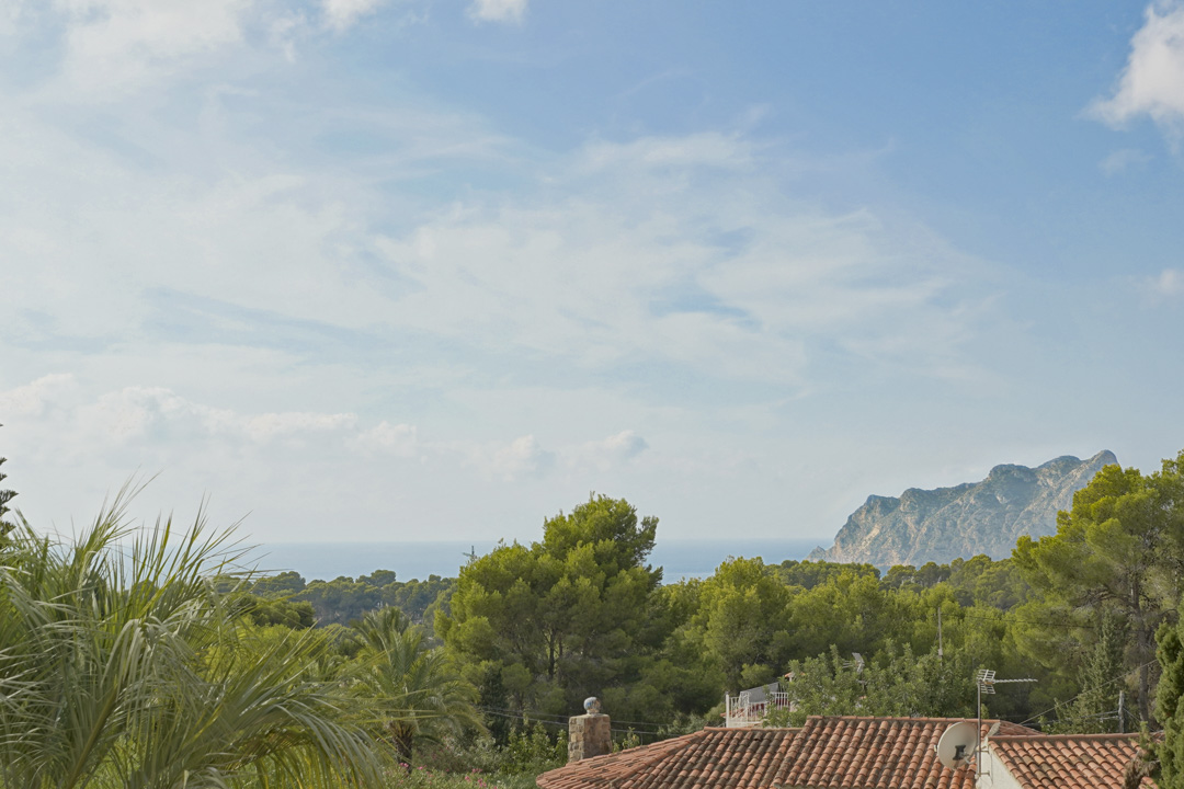 Panoramablick auf das Mittelmeer und den Peñón de Ifach von der oberen Etage, umrahmt von üppigen Pinien und mediterraner Vegetation.