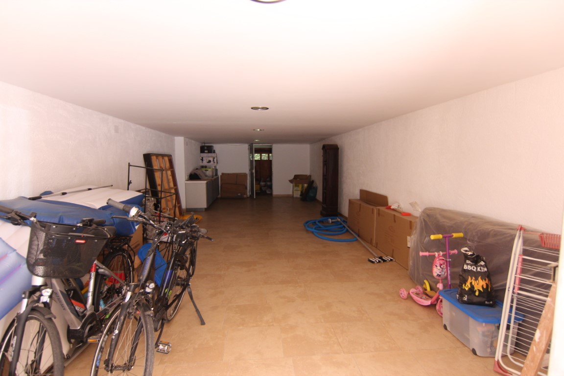 Geräumige 60m2 Garage mit Fliesenboden, weißen Wänden und Einbaustrahlern, die viel Platz für Lagerung und Parkmöglichkeiten bietet.
