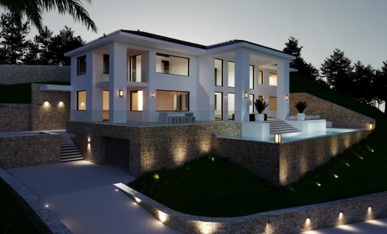 Abendliche Außenansicht der Villa mit weißer Fassade, Natursteinmauern, beleuchtetem Infinity-Pool und integrierter Garageneinfahrt im Untergeschoss.
