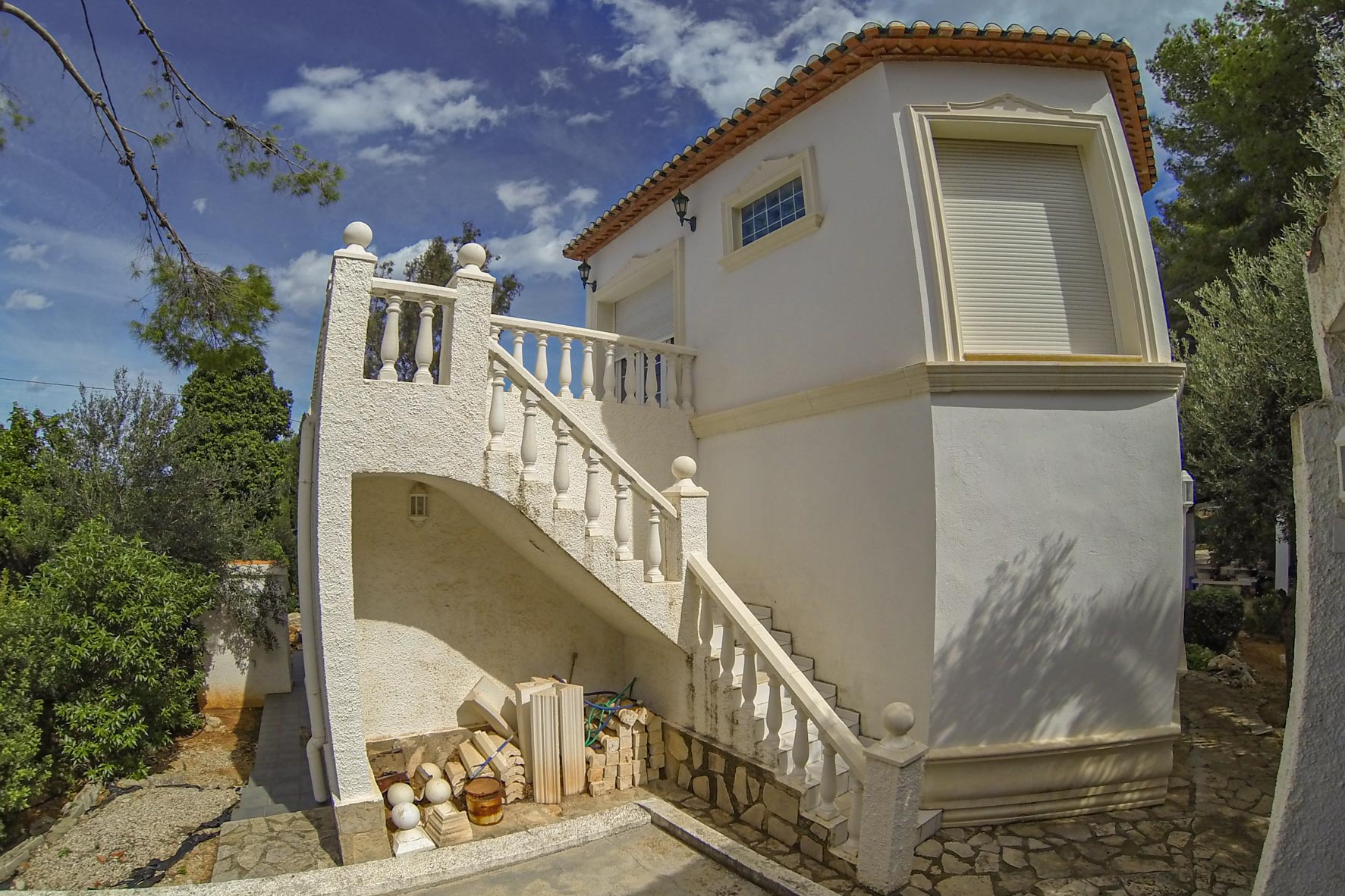 Außenansicht der weißen Steintreppe mit Balustrade, die zum Turm der Villa führt.