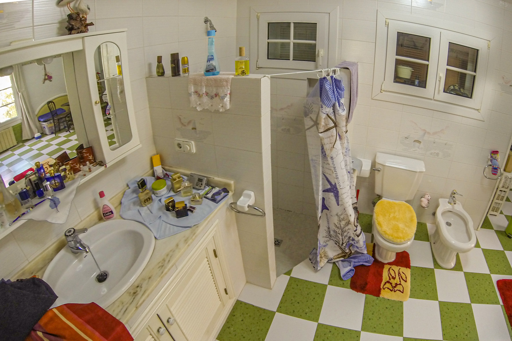 Badezimmerdetail mit Aufsatzwaschbecken und Dusche mit gemustertem Vorhang.