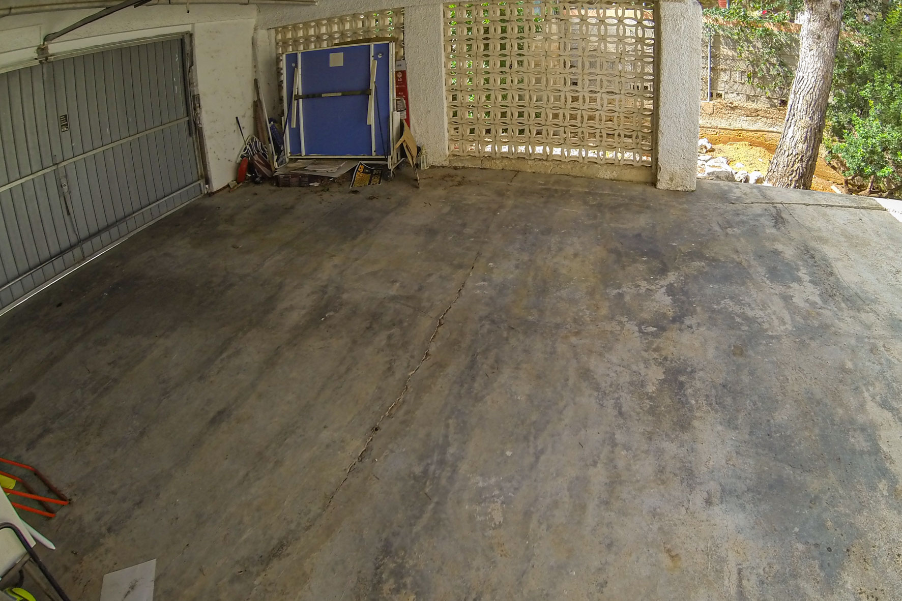 Garage mit Metalltor und dekorativer Blockwand.