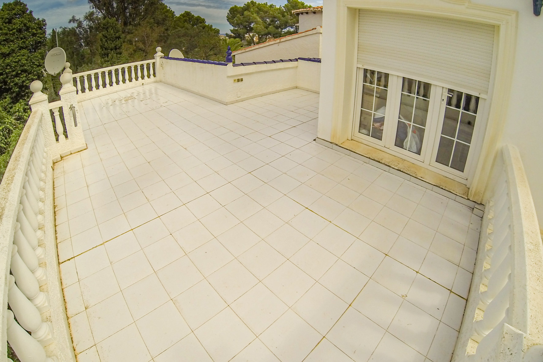 Weitläufige Terrasse mit weißen Fliesen und Balustradengeländer, ideal für den Genuss im Freien.