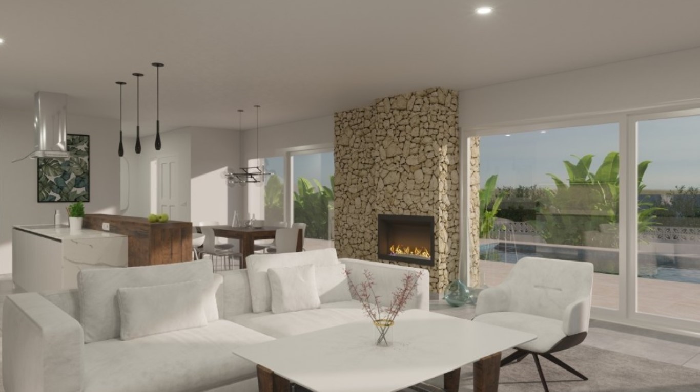 Offener Wohnbereich mit Natursteinwand und integriertem Kamin, moderner Küche mit Holztheke und großen Glasfronten mit Blick auf die Terrasse und den Pool.