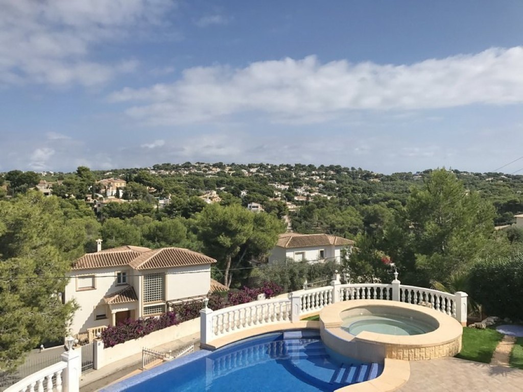 Außenanlage mit geschwungenem Pool und integriertem runden Whirlpool, mit Panoramablick über das bewaldete Tal und die umliegenden Villen in Javea.