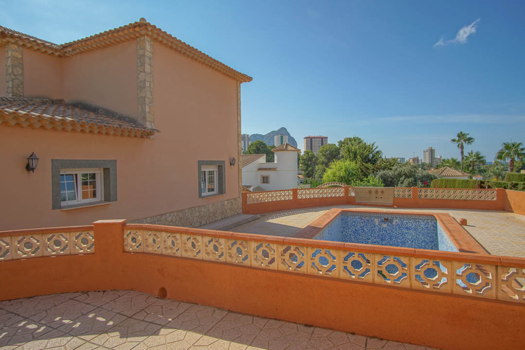 Erhöhte Terrasse mit privatem Pool und dekorativer Balustrade, die einen weiten Blick auf den Peñón de Ifach und die Skyline bietet.
