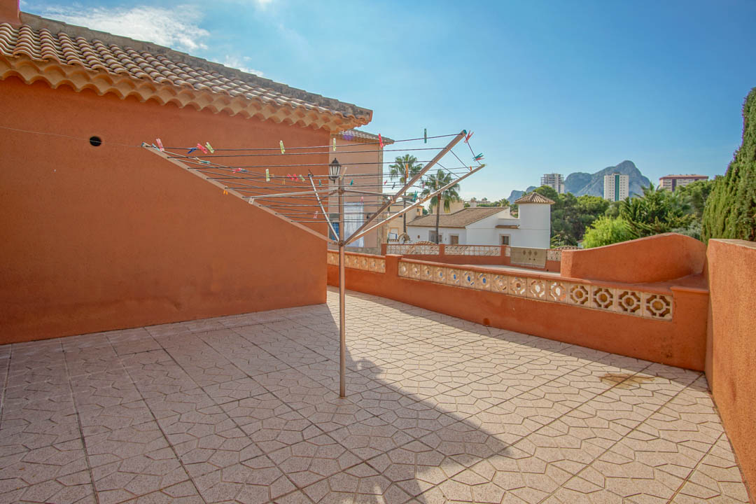 Solarium-Terrasse mit gemusterten Bodenfliesen und terracottafarbenen Wänden, die einen weiten Blick auf den Peñón de Ifach bietet.