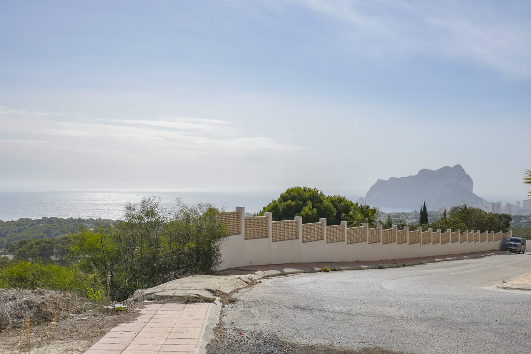 Panoramablick von der Zufahrtsstraße mit der Grundstücksmauer und dem markanten Peñón de Ifach vor der Kulisse des Mittelmeers.