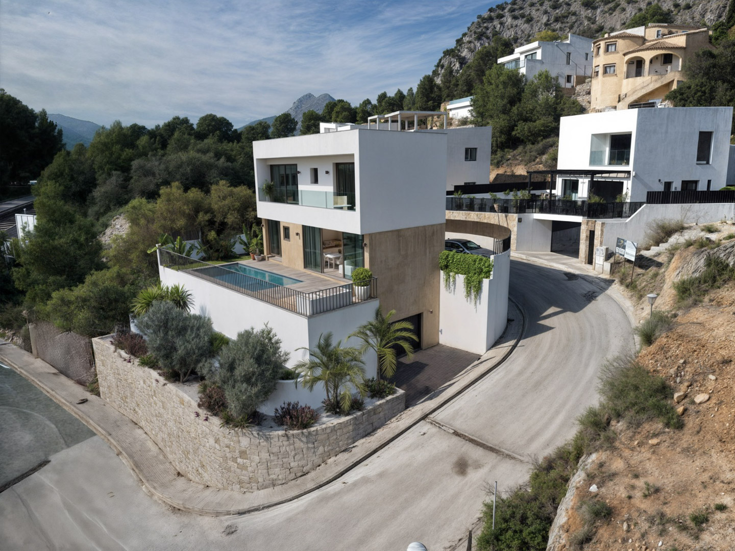 Außenansicht der modernen Villa mit weißer Fassade, Steinelementen, privatem Pool auf der Terrasse und Blick auf die Bergketten des Pop-Tals.