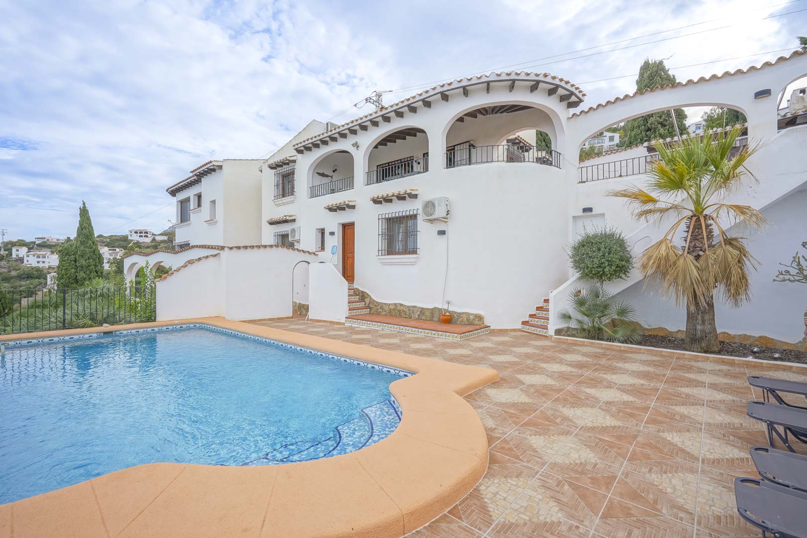 Außenansicht der Villa mit Pool, gefliester Terrasse und Architektur im kastilischen Stil.