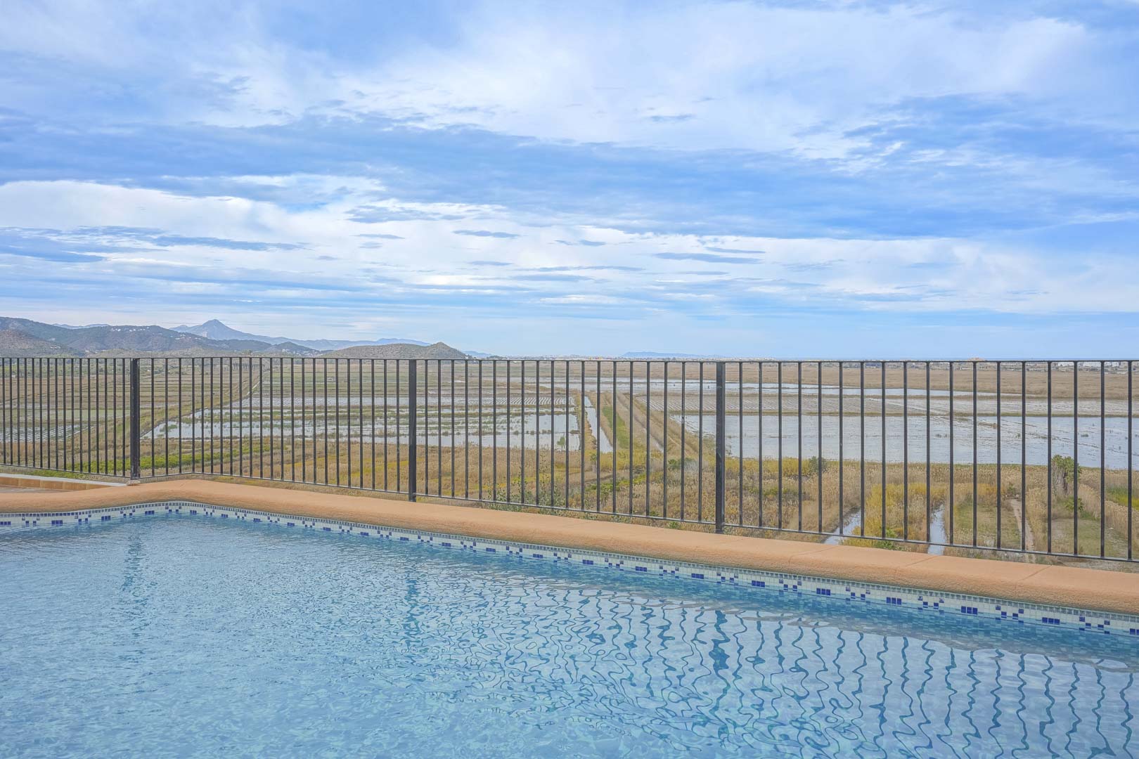 Poolblick mit Geländer mit Blick auf die Landschaft Marjal de Pego.