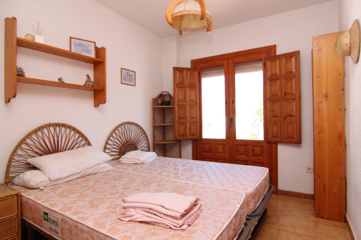 Schlafzimmer mit Einzelbetten, Rattan-Kopfteilen und Holzarbeiten.