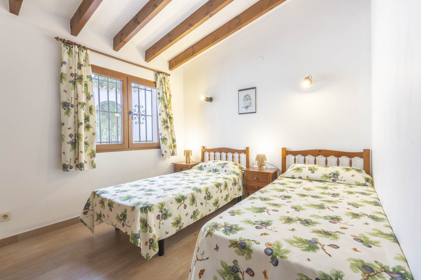Schlafzimmer mit zwei Einzelbetten, Holzbalken und traditionellem Dekor.