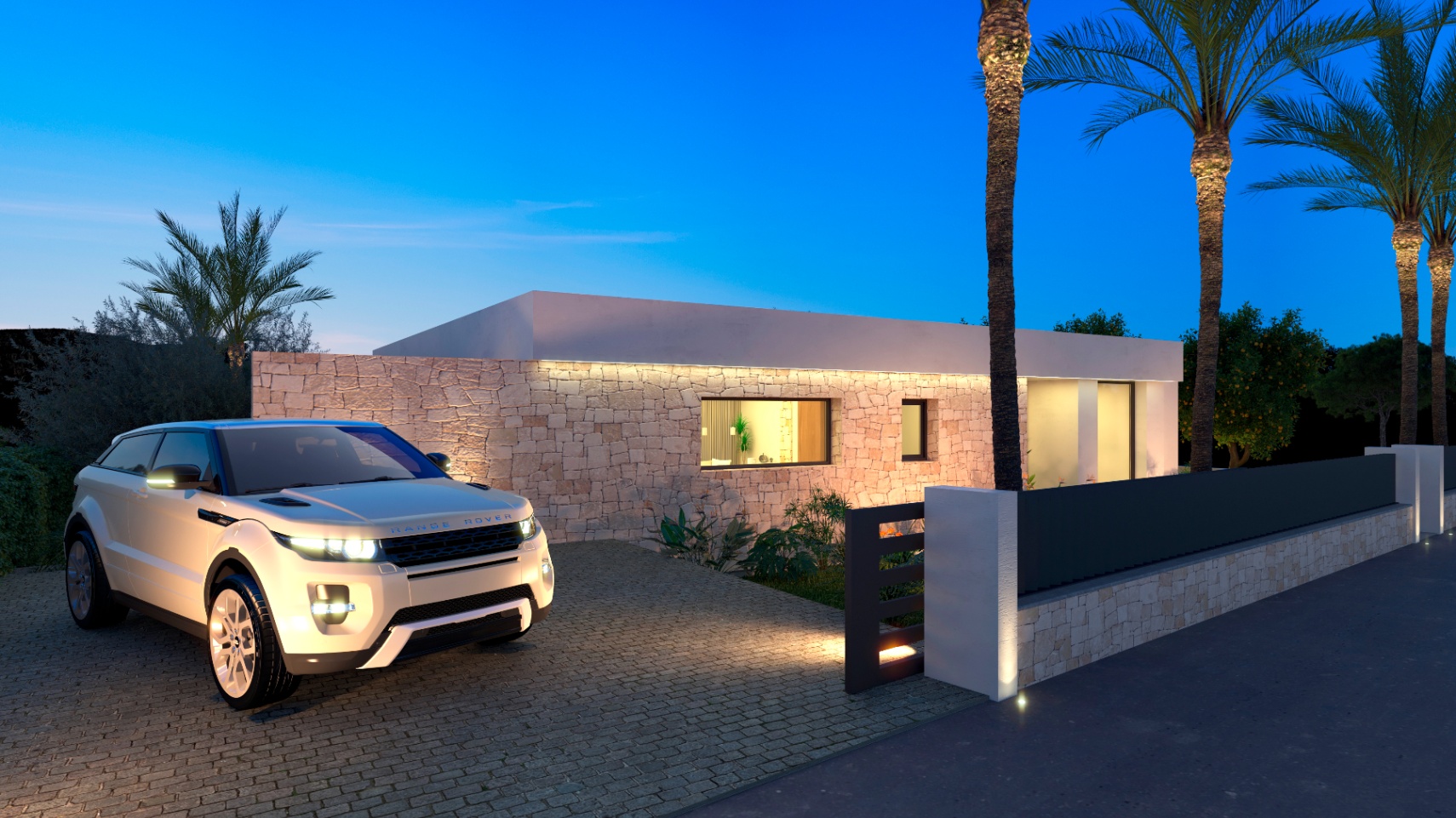 Außenansicht der Villa mit beleuchteter Steinfassade und Range Rover in der Einfahrt.