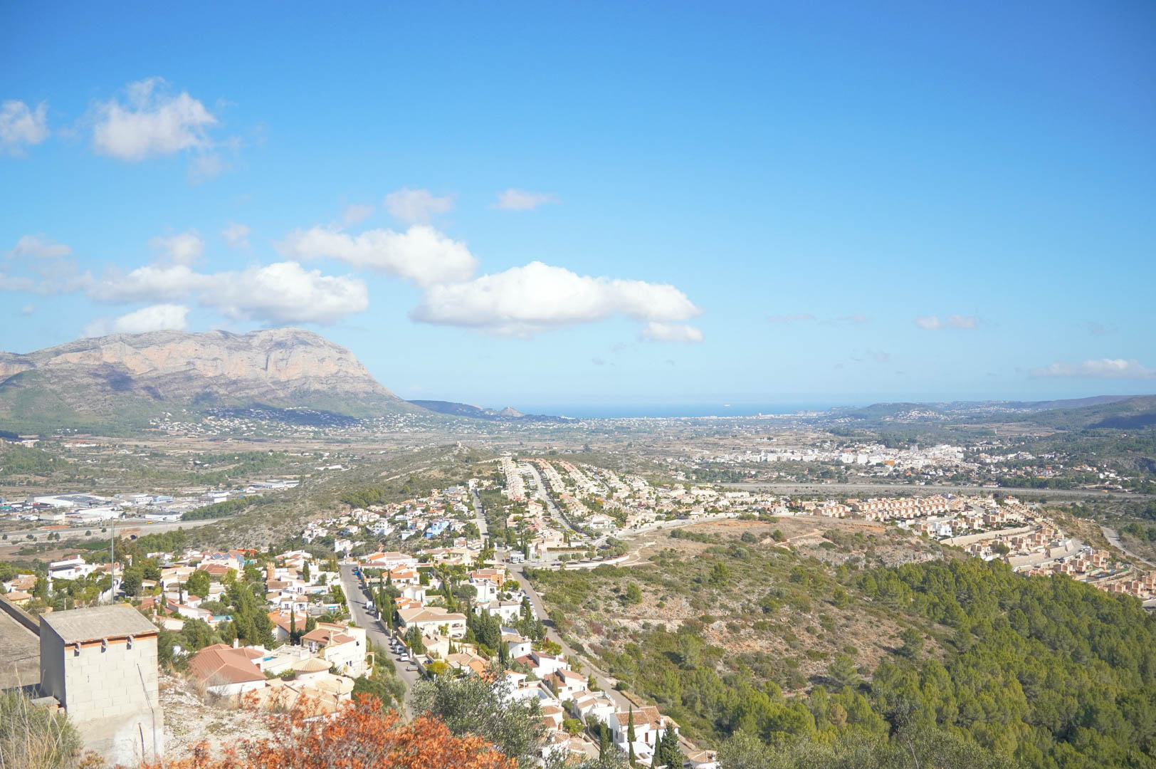 Panoramablick über das Pedreguer-Tal und das Montgó-Massiv, mit dem Mittelmeer am Horizont unter einem klaren blauen Himmel.