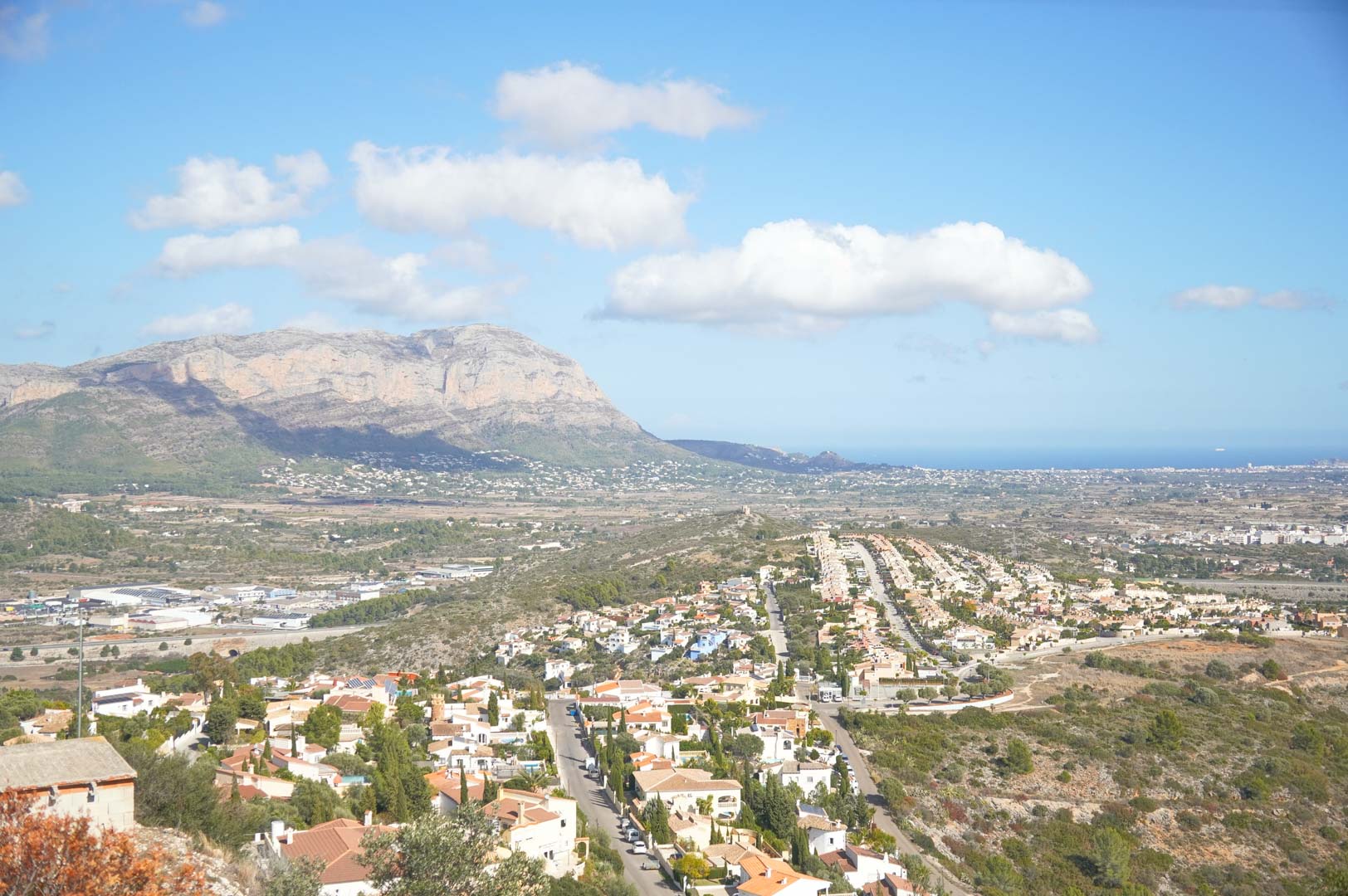 Panoramablick vom Anwesen über das Tal, mit den markanten Bergen und dem weiten Mittelmeer am Horizont unter blauem Himmel.