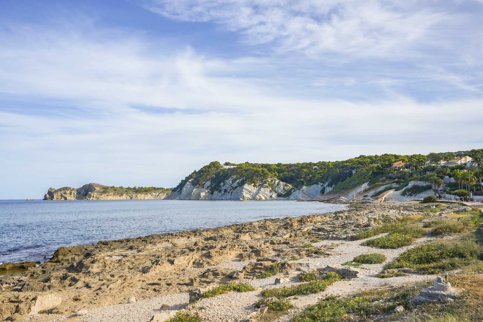 Panoramablick auf die felsige Küste von Jávea mit Kalksteinfelsen und dem mediterranen Ufer unter klarem Himmel.