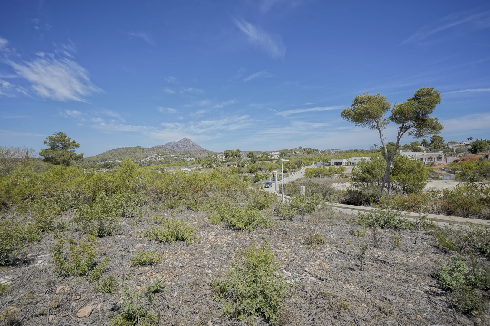 Panoramablick vom Grundstück auf das Montgó-Massiv, umgeben von mediterraner Vegetation und weitem blauem Himmel in der Wohngegend Valsol.