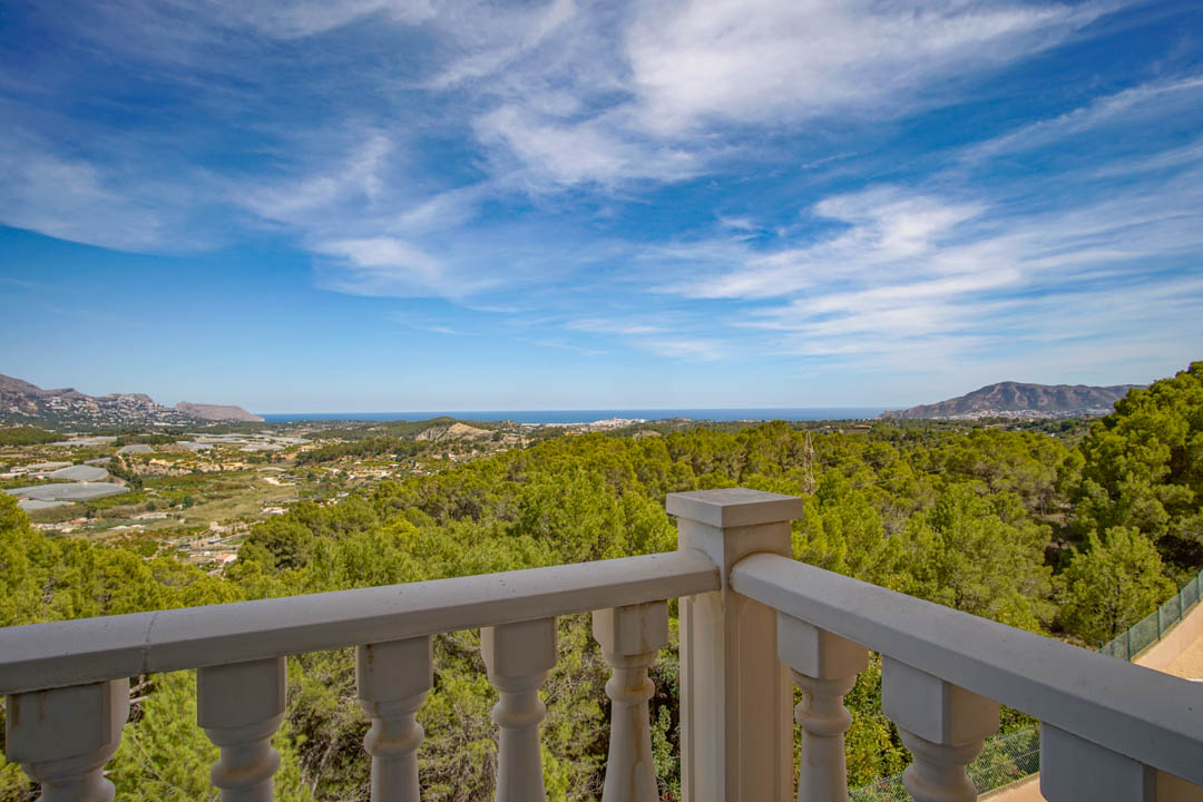Panoramablick von der Terrasse mit klassischer Balustrade auf das Mittelmeer und die dichten Pinienwälder der Region La Nucía.