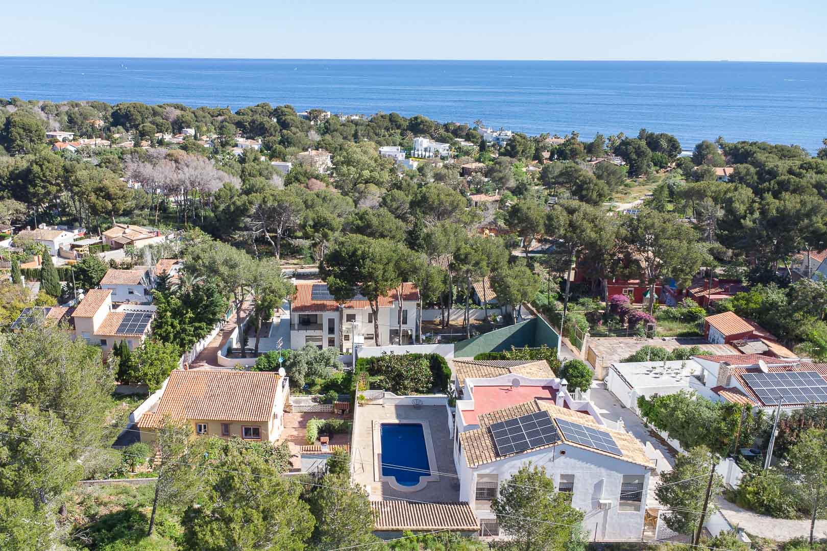 Luftaufnahme der Villa in Las Rotas mit privatem Pool, Solarmodulen und üppiger mediterraner Vegetation mit Blick auf das Meer.