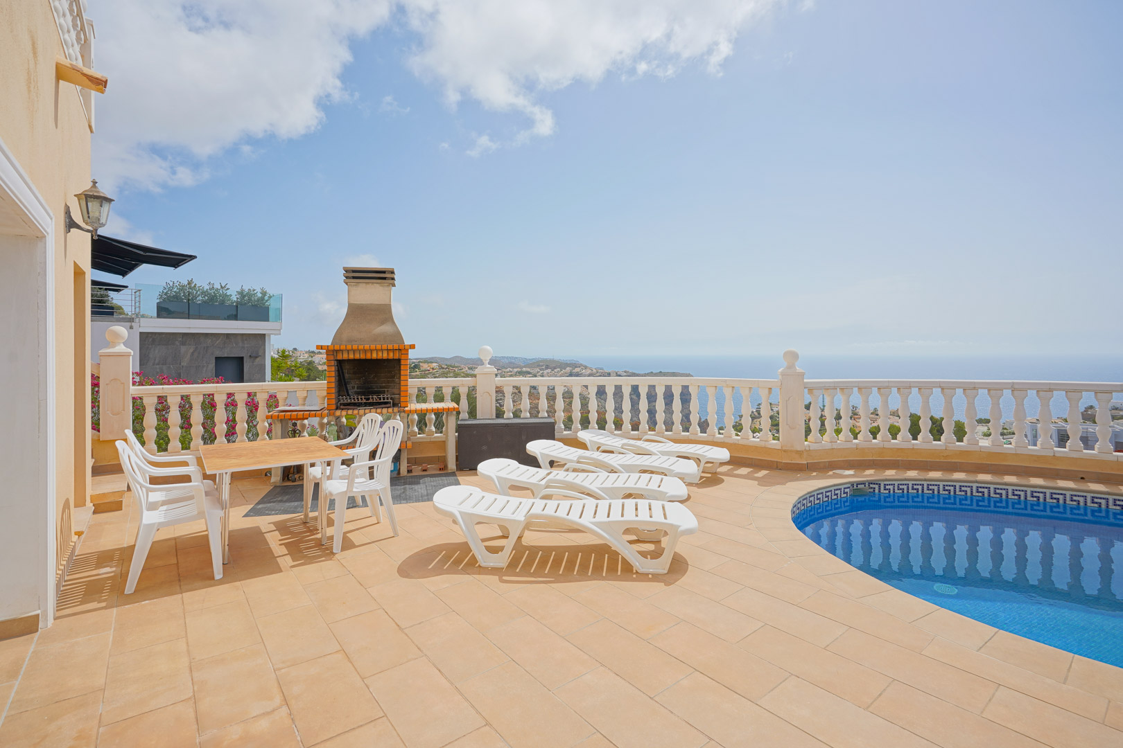 Außenbereich mit geschwungenem Pool, gemauertem Grill und Sonnenterrasse mit weitem Blick auf das Mittelmeer und die Küstenlandschaft.