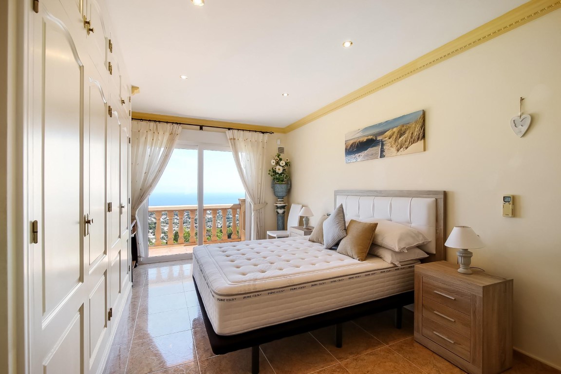Hauptschlafzimmer mit raumhohen Einbauschränken und direktem Zugang zur Terrasse mit weitem Blick auf das Mittelmeer.