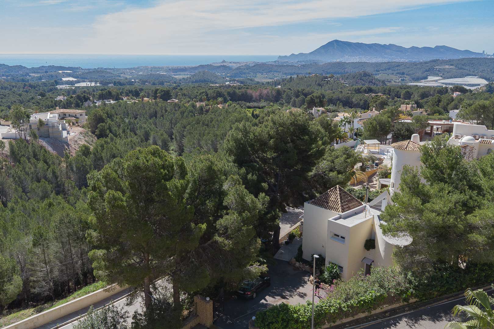 Erhöhte Panorama-Aussicht auf die Villa inmitten von Pinien, mit weitem Blick auf das Mittelmeer und die umliegende Berglandschaft.