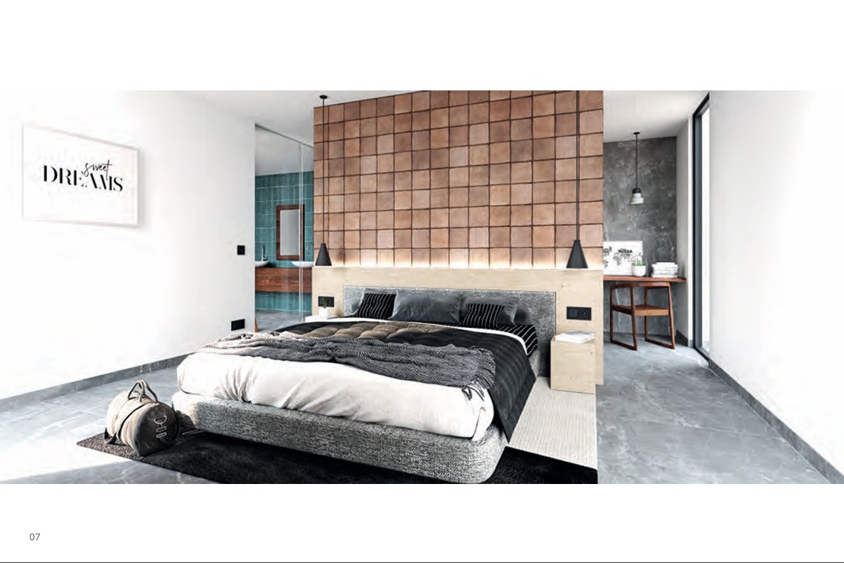 Hauptschlafzimmer mit Akzentwand aus Terrakotta-Fliesen, beleuchtetem Holz-Kopfteil und angrenzendem Badezimmer, das durch eine Glaswand sichtbar ist.