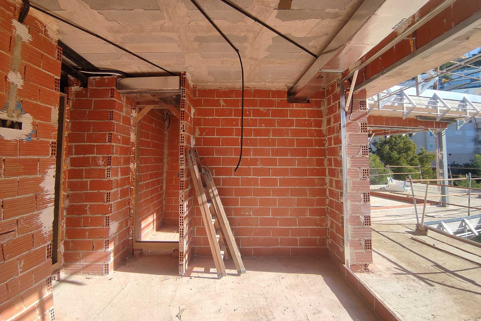 Baufortschritt der Villa mit Ziegelwänden, Betondecken sowie der Installation von Klimaanlagen-Lüftungskanälen und elektrischen Leitungen.