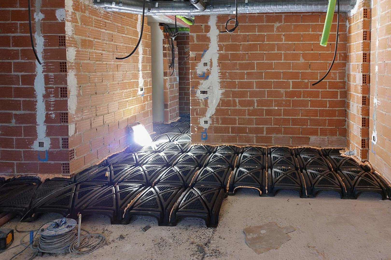 Bauphase mit Installation eines belüfteten Hohlraumbodensystems zur Sicherstellung der strukturellen Isolierung und des Feuchtigkeitsschutzes.