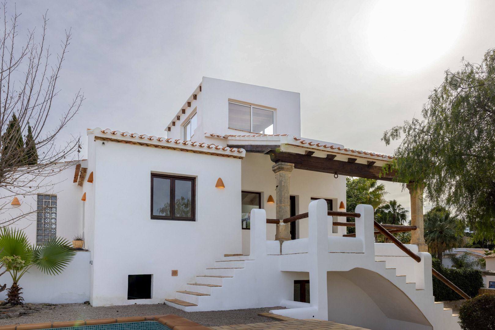 Außenansicht der Villa mit Haupteingang, Zugangstreppe und mediterranen architektonischen Details.
