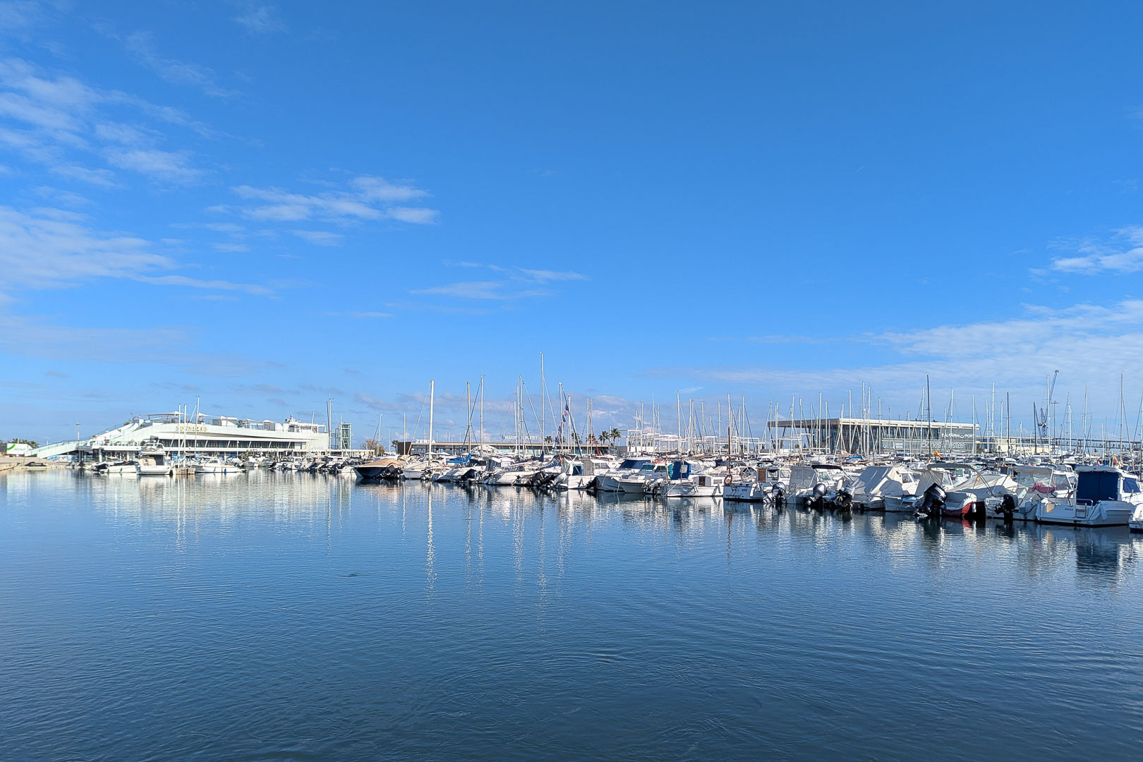 Ansicht des Yachthafens mit mehreren Booten unter einem klaren blauen Himmel.