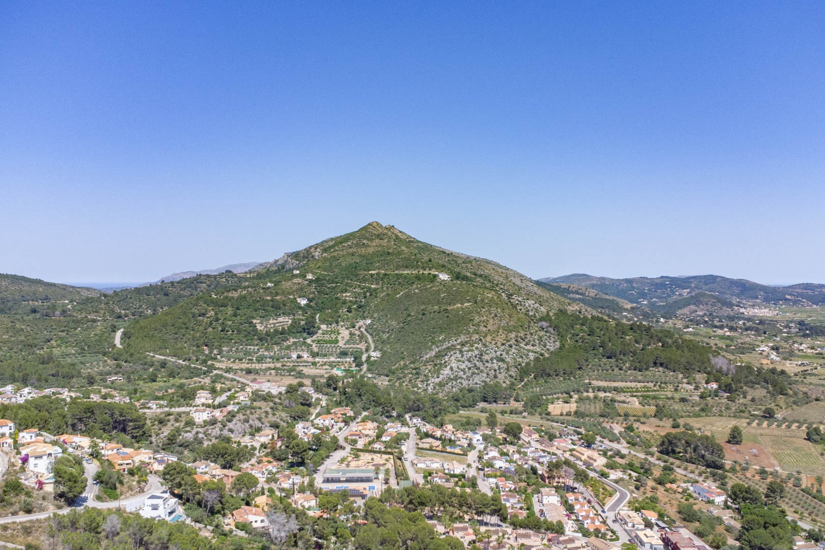 Luftaufnahme von Alcalalí und dem Jalón-Tal, die die natürliche Landschaft und die erhöhte Lage der Wohngrundstücke verdeutlicht.