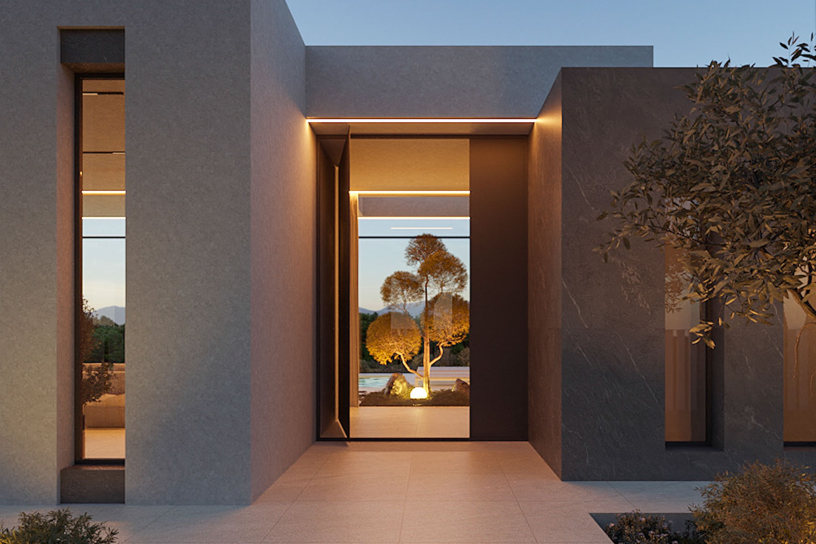 Minimalistischer Haupteingang mit grauer Steinverkleidung, integrierten LED-Lichtleisten und Blick auf den beleuchteten mediterranen Garten.