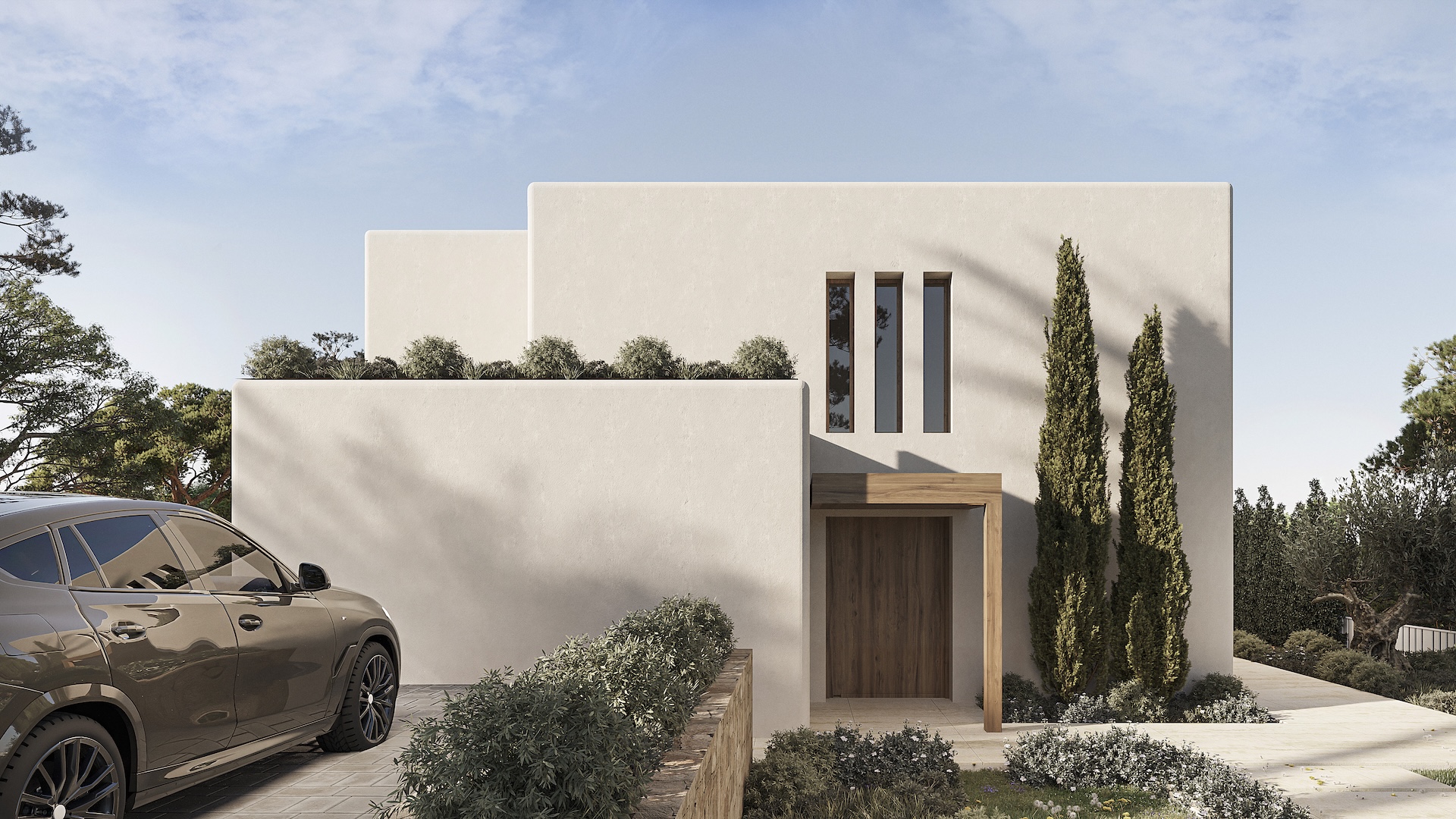 Hauptfassade im ibizenkischen Stil mit weiß strukturierten Wänden, Holzeingangstür unter einem Sturz und schmalen vertikalen Fenstern. Der Zugang ist gepflastert und mit Zypressen gesäumt.