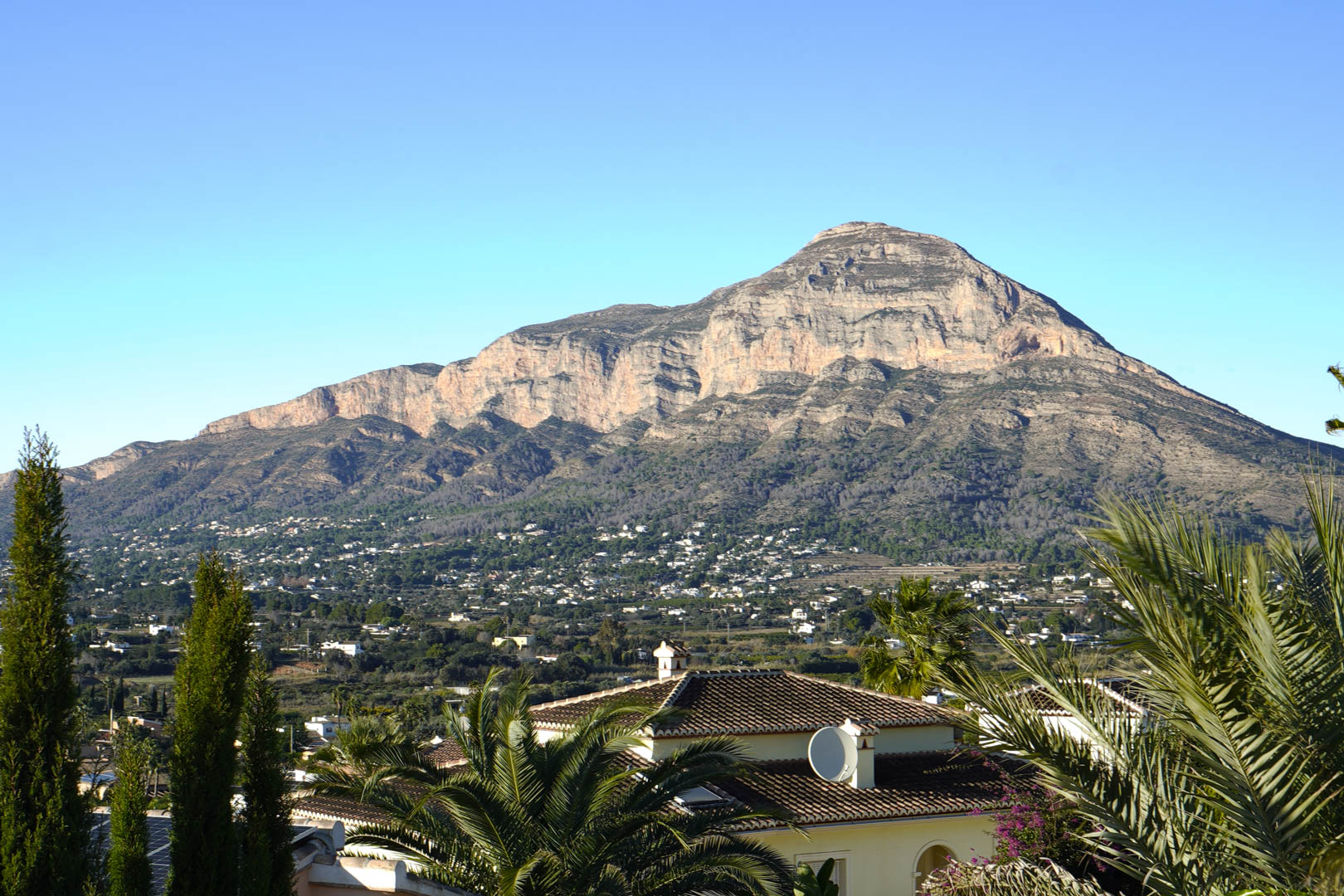 Panoramablick auf die Villa mit dem Montgó im Hintergrund, der die architektonische Integration in die Landschaft hervorhebt.