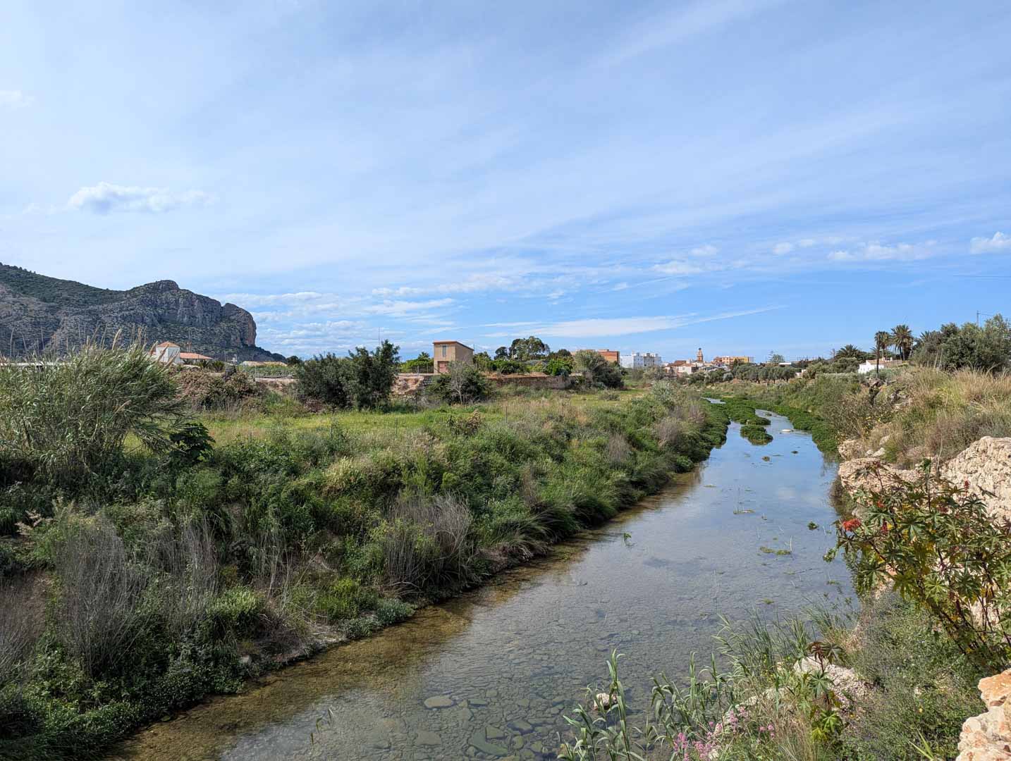 Blick auf die natürliche Umgebung mit einem Flusslauf und dem Segaria-Gebirge im Hintergrund, die die ruhige Lage nahe El Vergel unterstreicht.