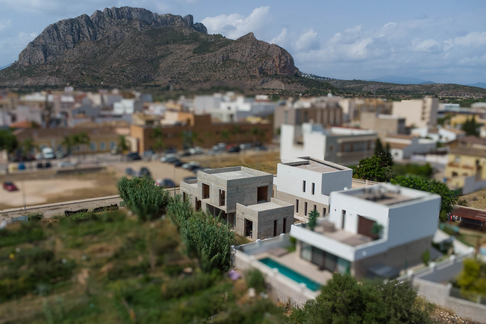 Luftaufnahme von drei modernen Villen im Bau in El Vergel, mit Blick auf die Segaria-Berge und die umliegende mediterrane Landschaft.