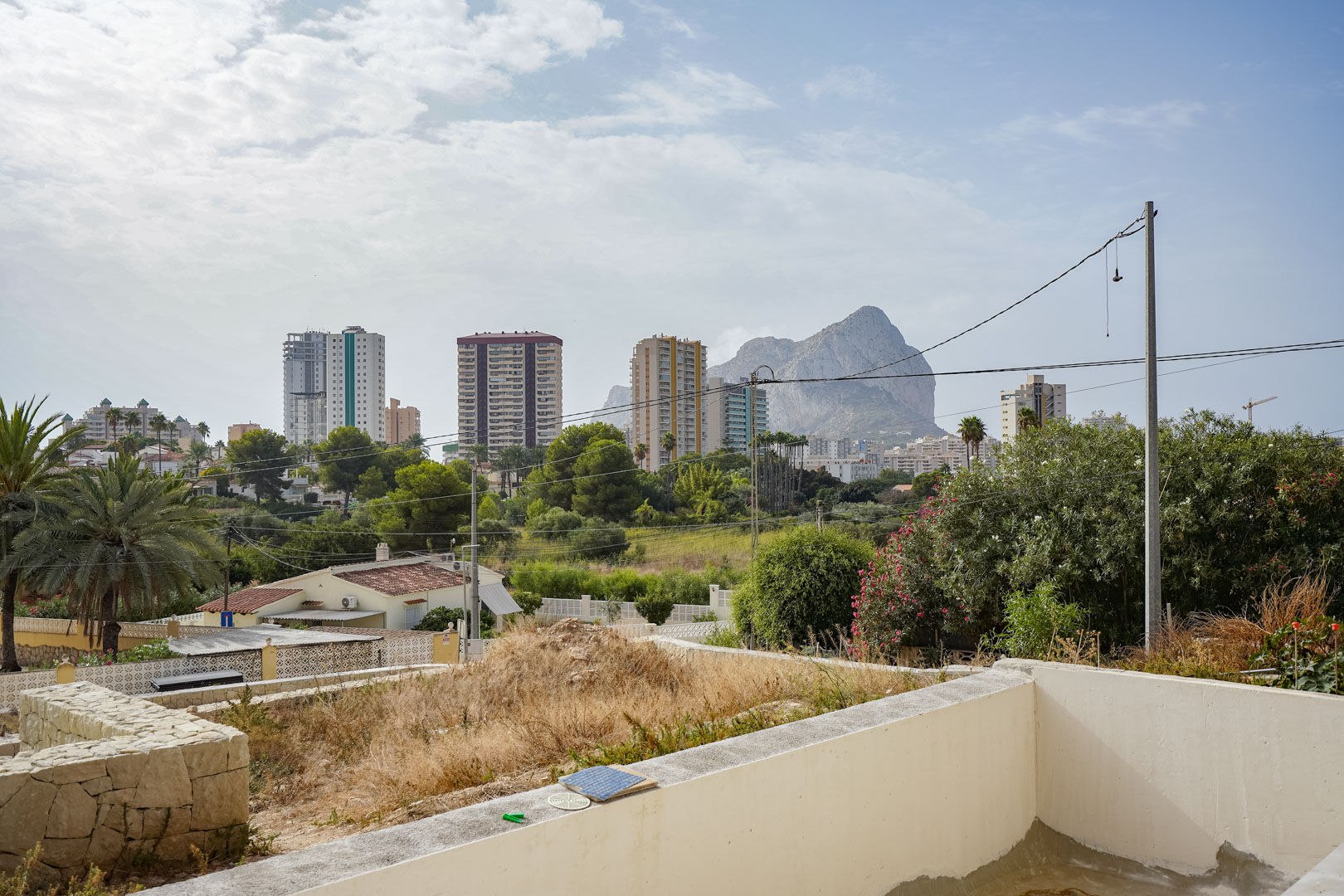 Freier Blick auf den Peñón de Ifach und die Skyline von Calpe vom erhöhten Grundstück der künftigen Villa aus, umgeben von mediterraner Natur.