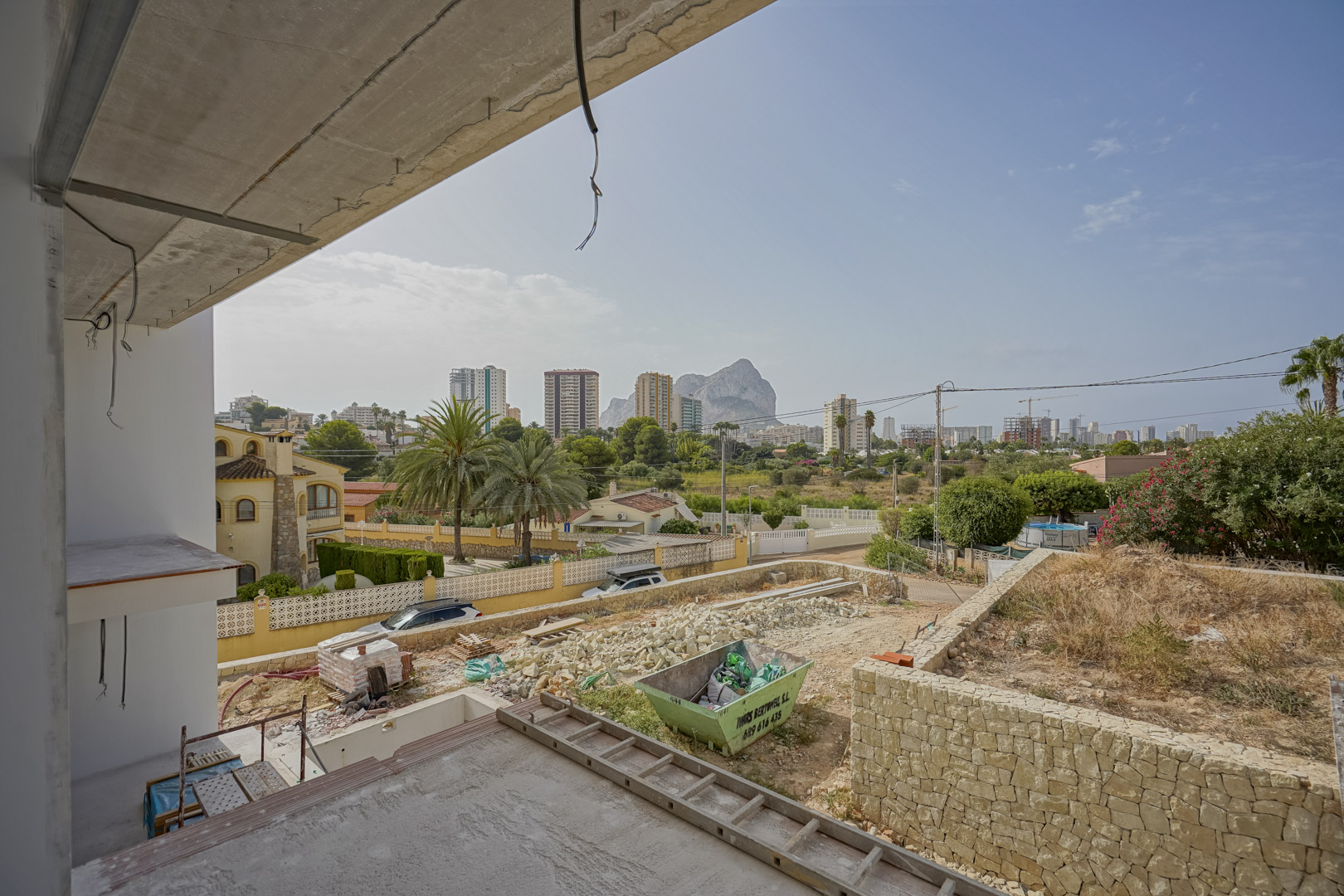 Panoramablick aus dem im Bau befindlichen Obergeschoss auf den Peñón de Ifach und die Skyline von Calpe über dem künftigen Gartengelände.