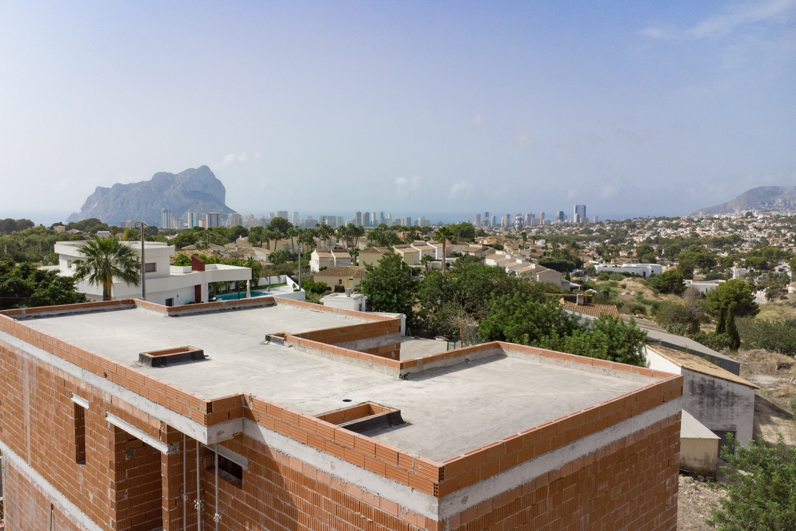 Weitblick vom Rohbau auf die Skyline von Calpe und den Peñón de Ifach, der die exponierte Lage und den aktuellen Baufortschritt zeigt.