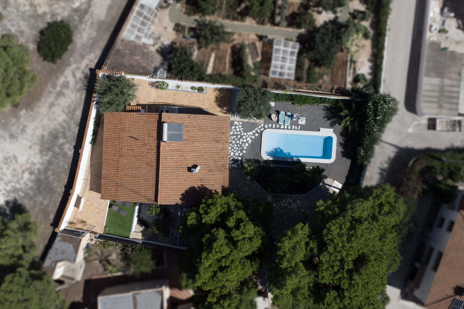 Luftaufnahme der Villa mit Darstellung der Grundstücksaufteilung, des rechteckigen Pools, der Terracotta-Terrassen und der Solaranlage auf dem Dach.