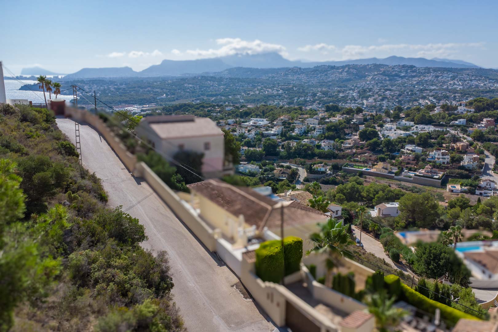 Erhöhter Panoramablick von El Portet auf die Küste von Moraira und das Mittelmeer, mit den Gebirgsketten der Marina Alta im Hintergrund.